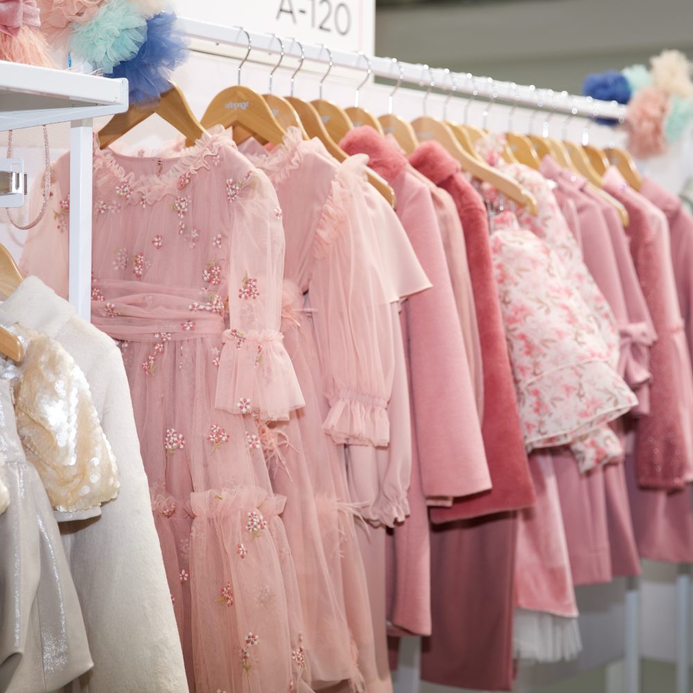 Pink and white children's clothes hung on a rail at Children's Show 