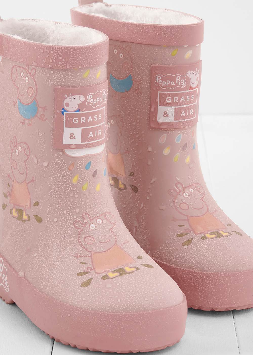 A pair of pink Grass & Air kids' wellington boots with a Peppa Pig print on them 