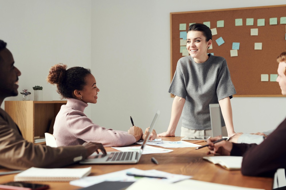 A group of people talking in a boardroom to represent someone selling their business