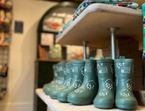 Green children's wellington boots displayed on a shelf in Margo's Petersfield