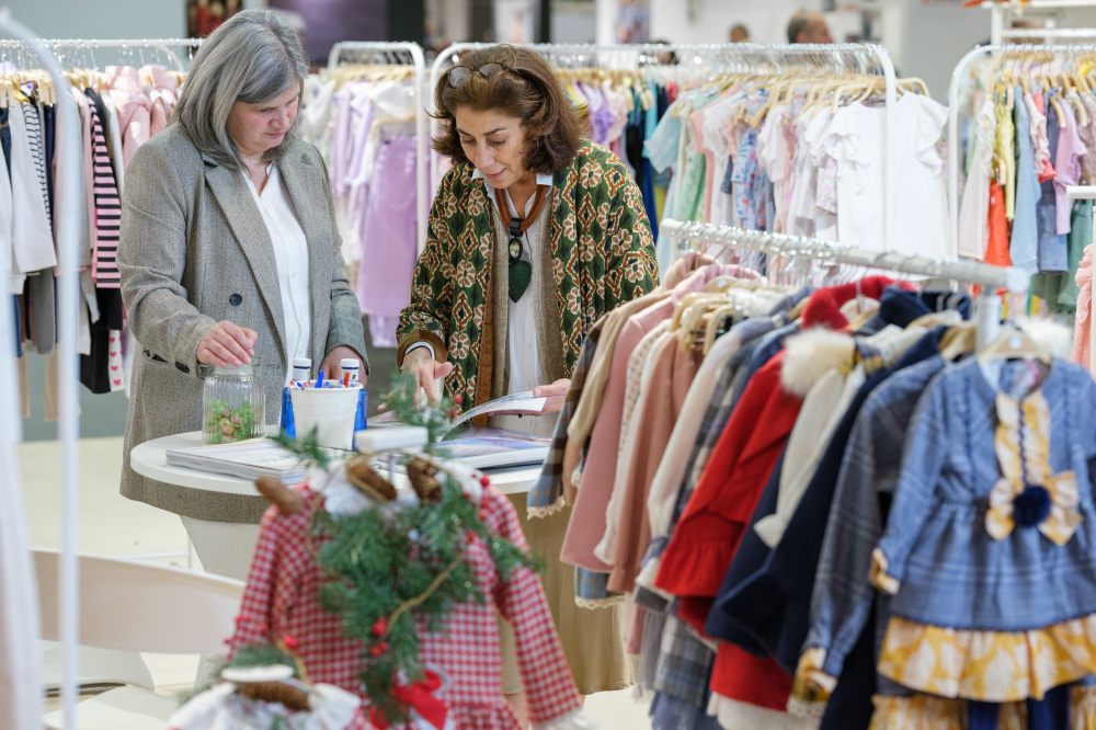 Two women on a childrenswear stand at the BKS + FIMI trade show