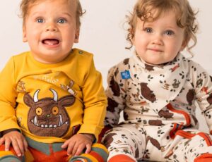 Two young children sat on the floor wearing outfits from the new Gruffalo collection by Blade & Rose