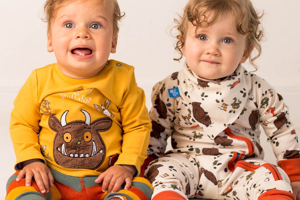 Two young children sat on the floor wearing outfits from the new Gruffalo collection by Blade & Rose