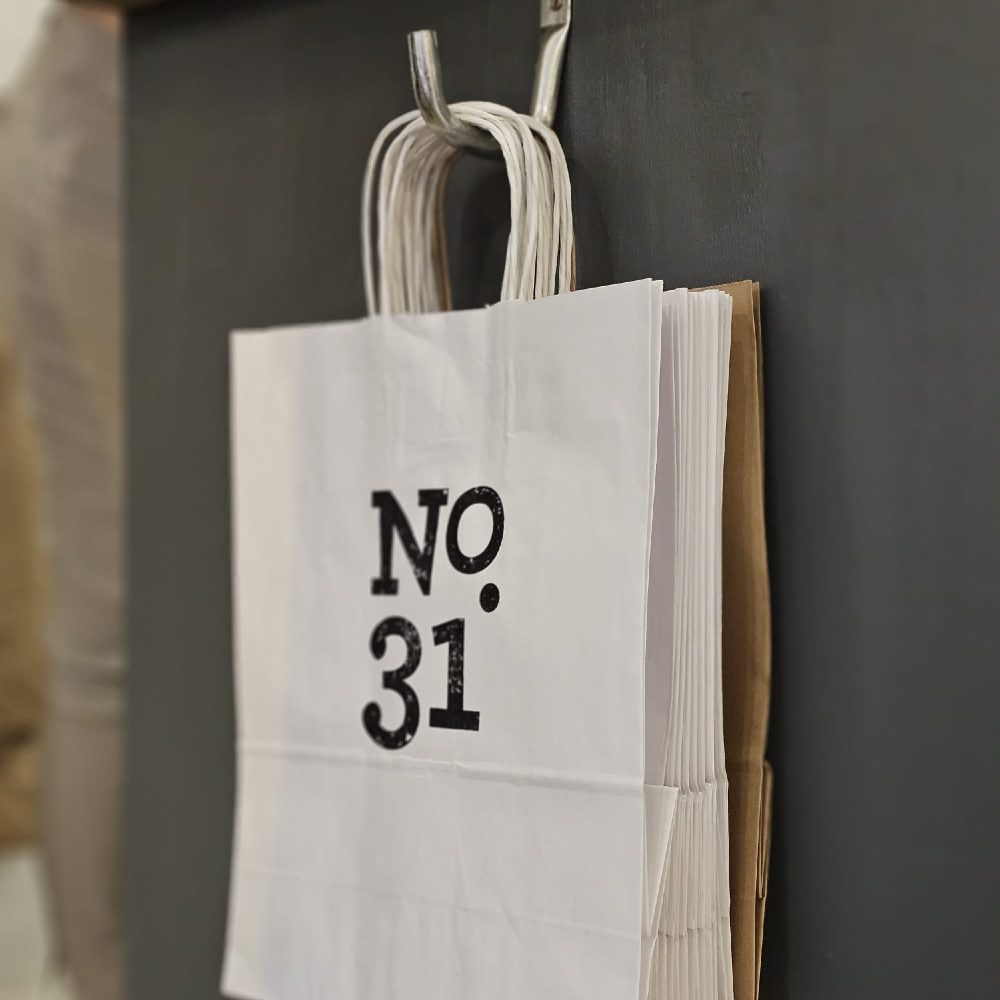 Paper bags with No. 31 on the front hung on a hook 