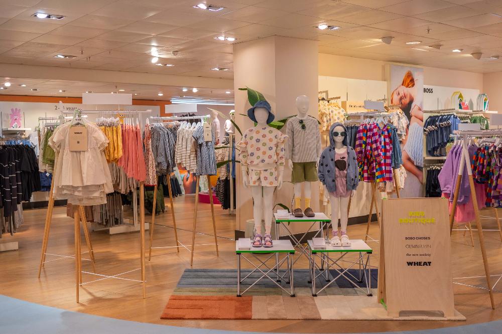 Children's clothes displayed on mannequins and rails in a John Lewis store