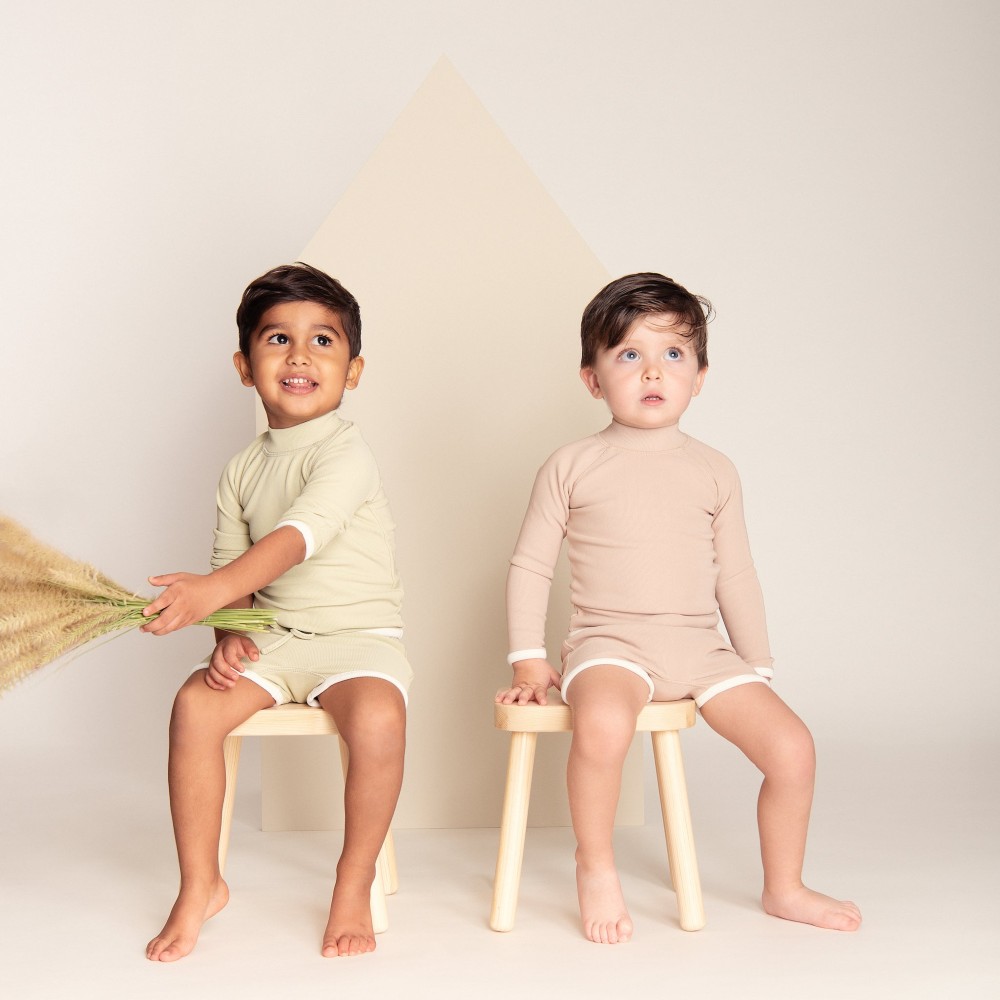 Two boys sat on white stools wearing shorts and T-shirts by Bodi Loves