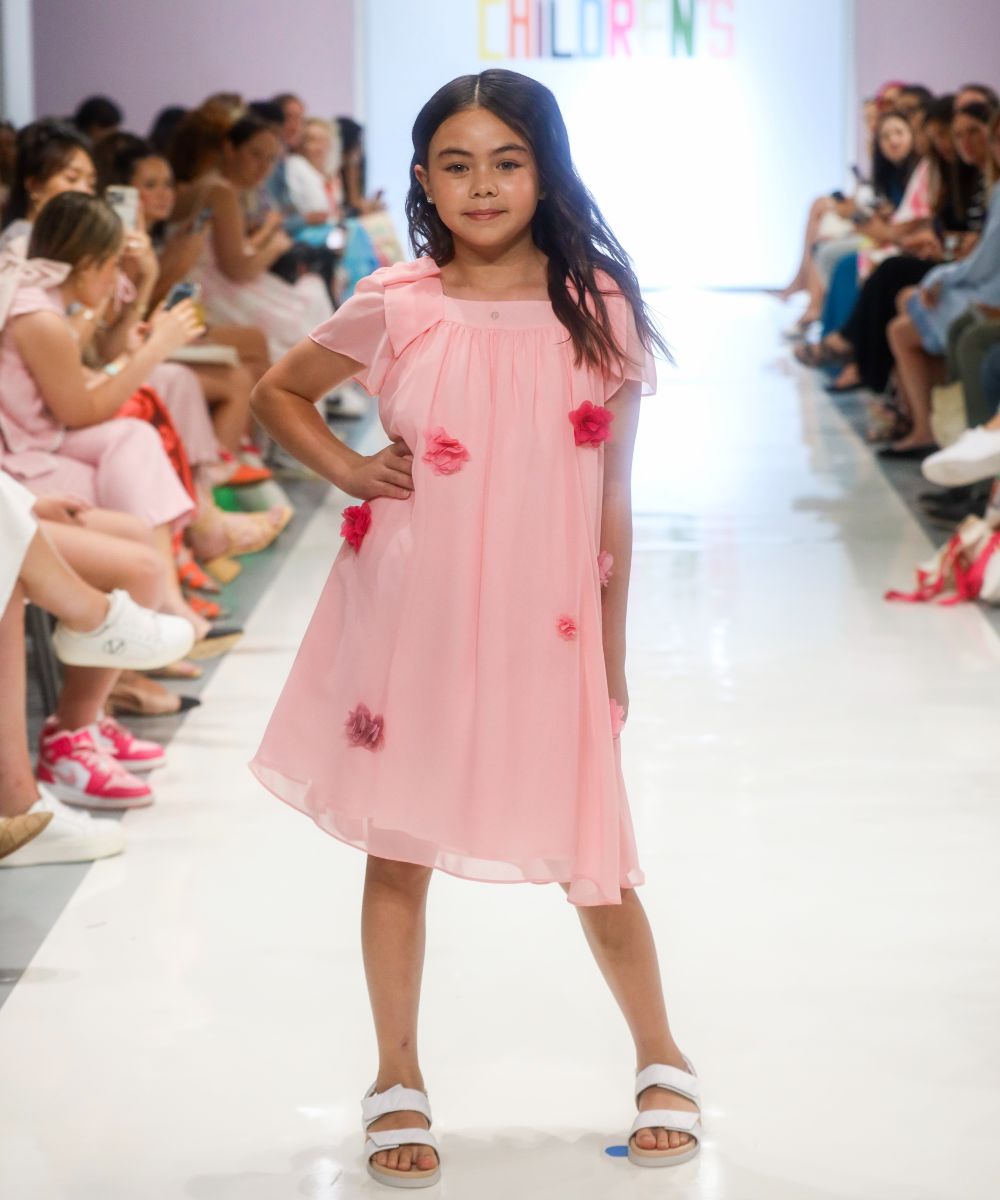 A girl in a pink dress stood on a catwalk