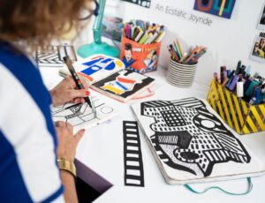 Artist Camille Walala drawing at a desk