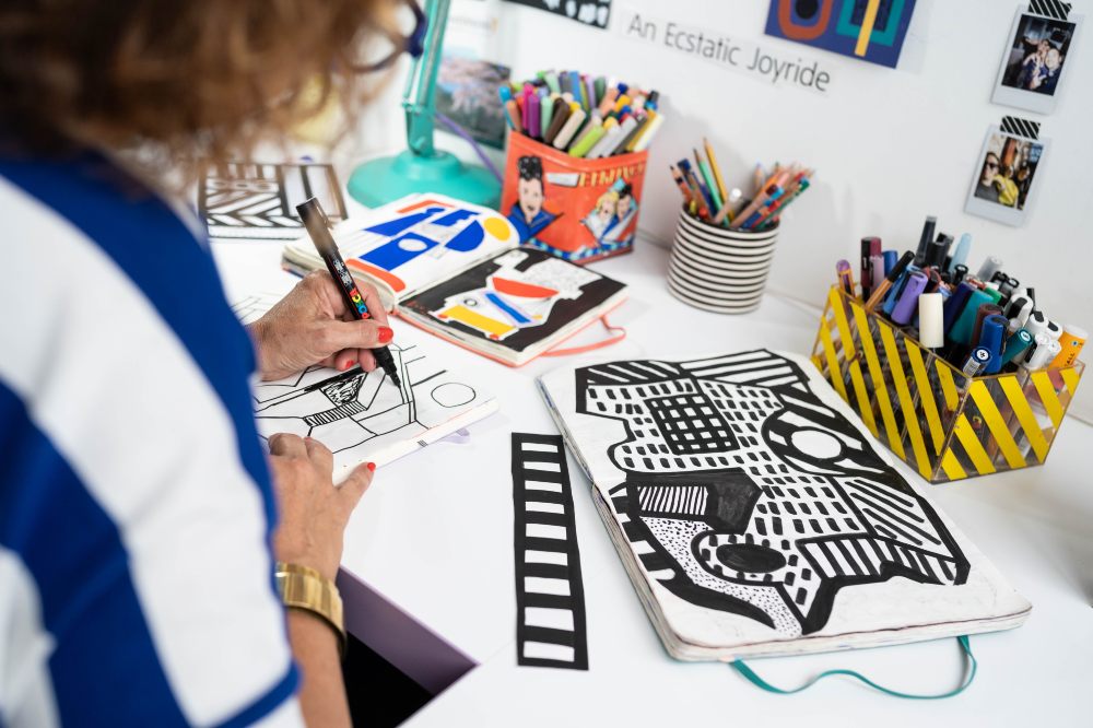 Artist Camille Walala drawing at a desk