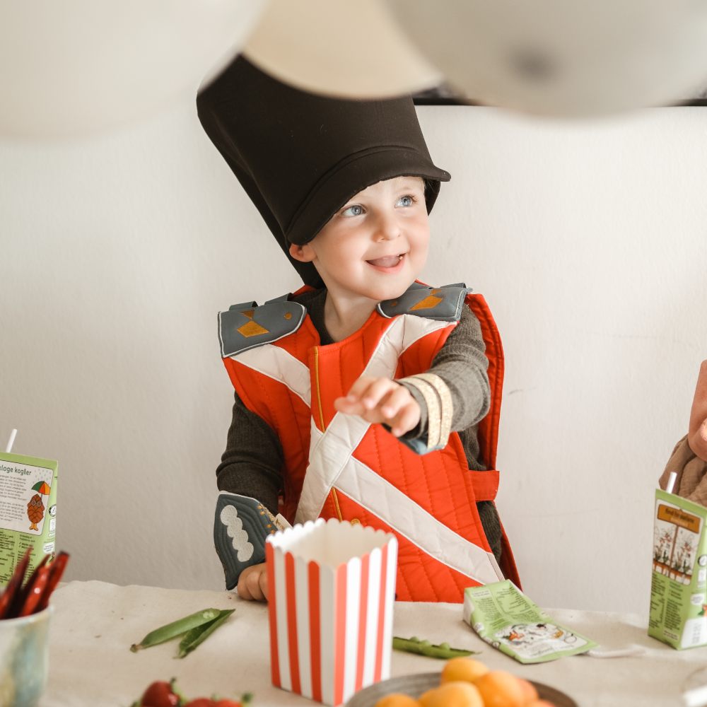 A young boy at a table in a dress-up soldier costume