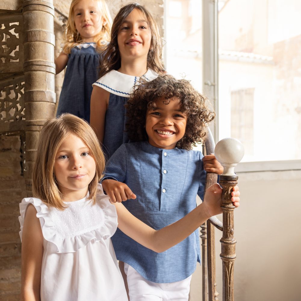 Four children stood at the bottom of a spiral staircase 