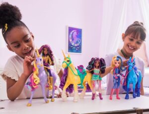 Two girls sat at a table playing with unicorn toys to illustrate INDX Toy & Gift show