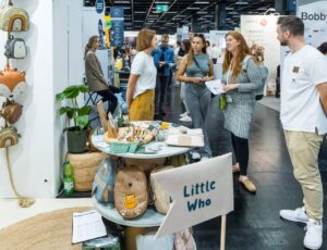 People stood talking in front of a stand at Kind + Jugend