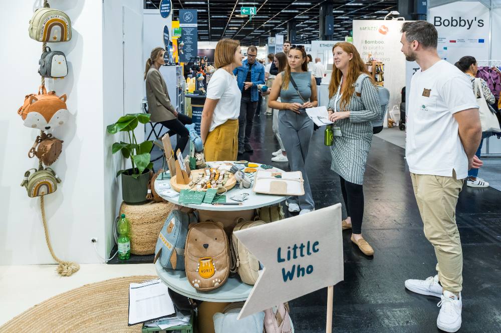 People stood talking in front of a stand at Kind + Jugend