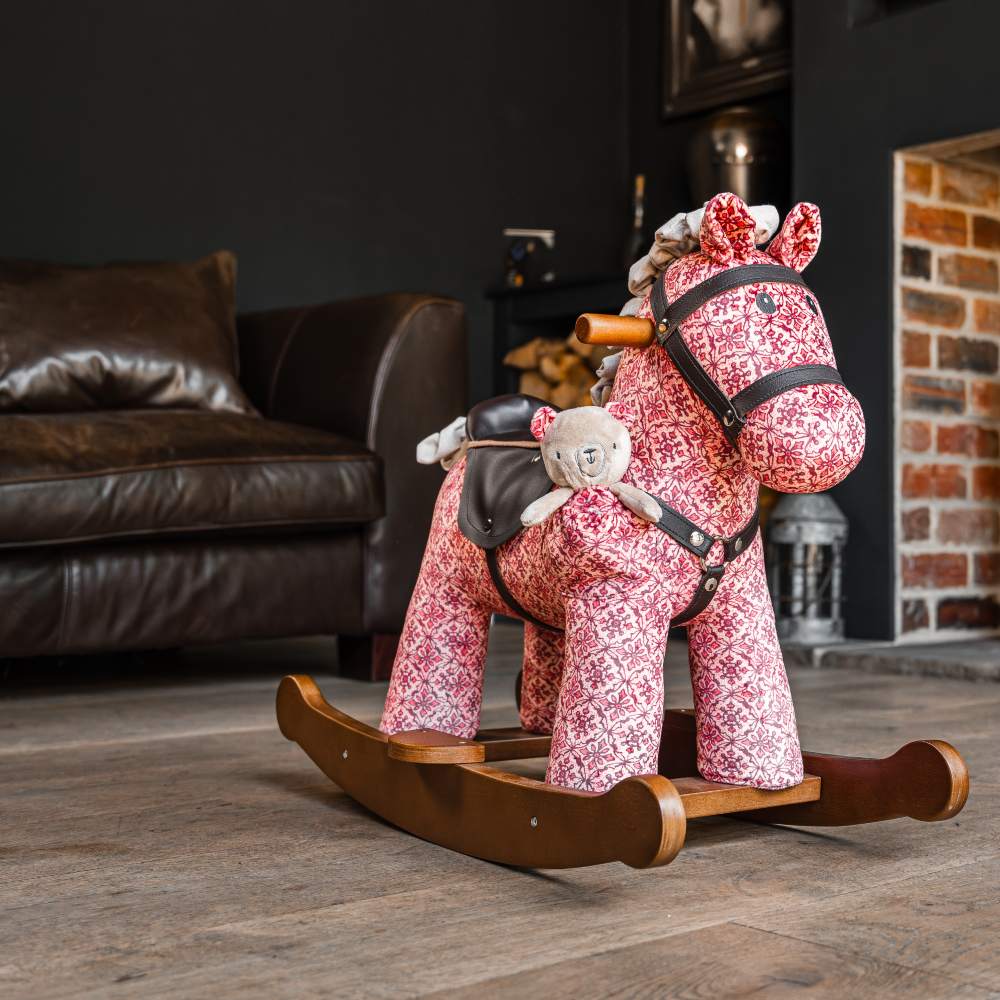 A red patterned fabric rocking horse displayed in a room