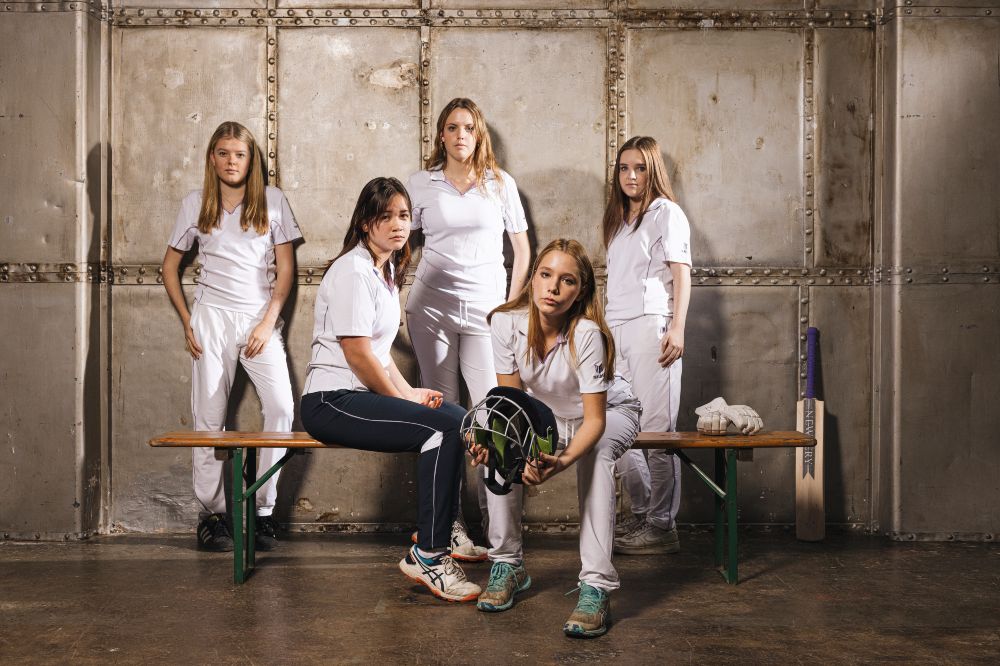 A group of girls in a changing room wearing cricket clothing by Maiden 