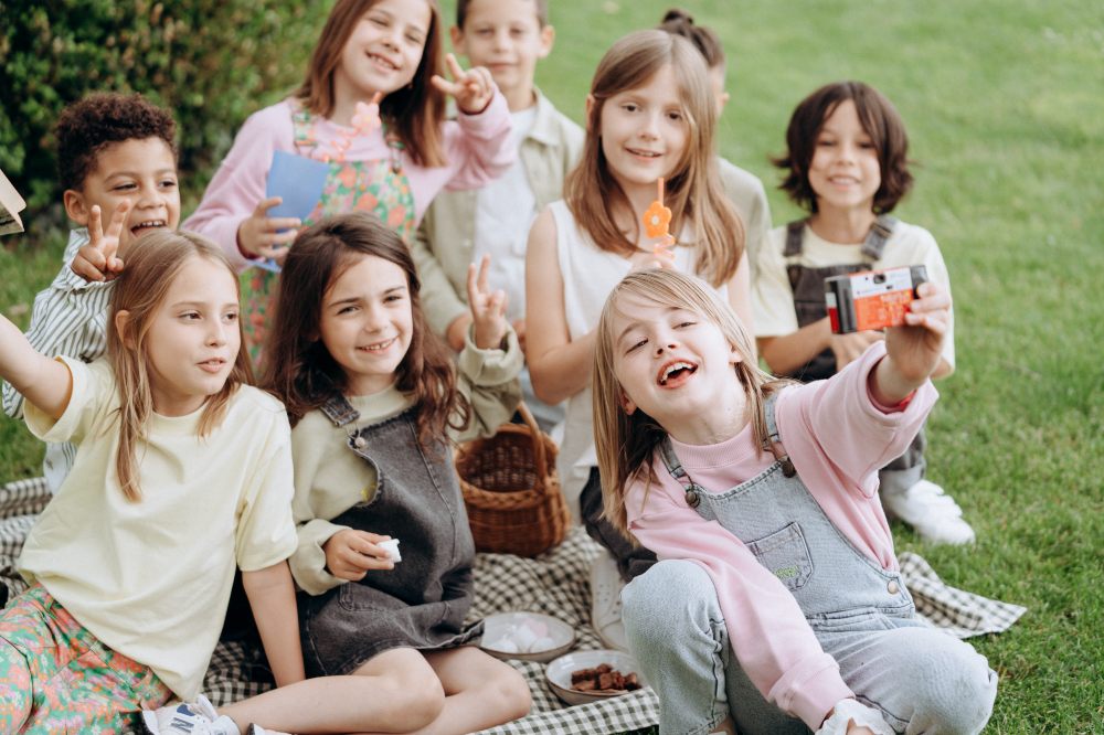 A group of children sat outside on a lawn