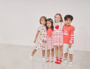 Four children stood together wearing summer outfits with fruit prints on them