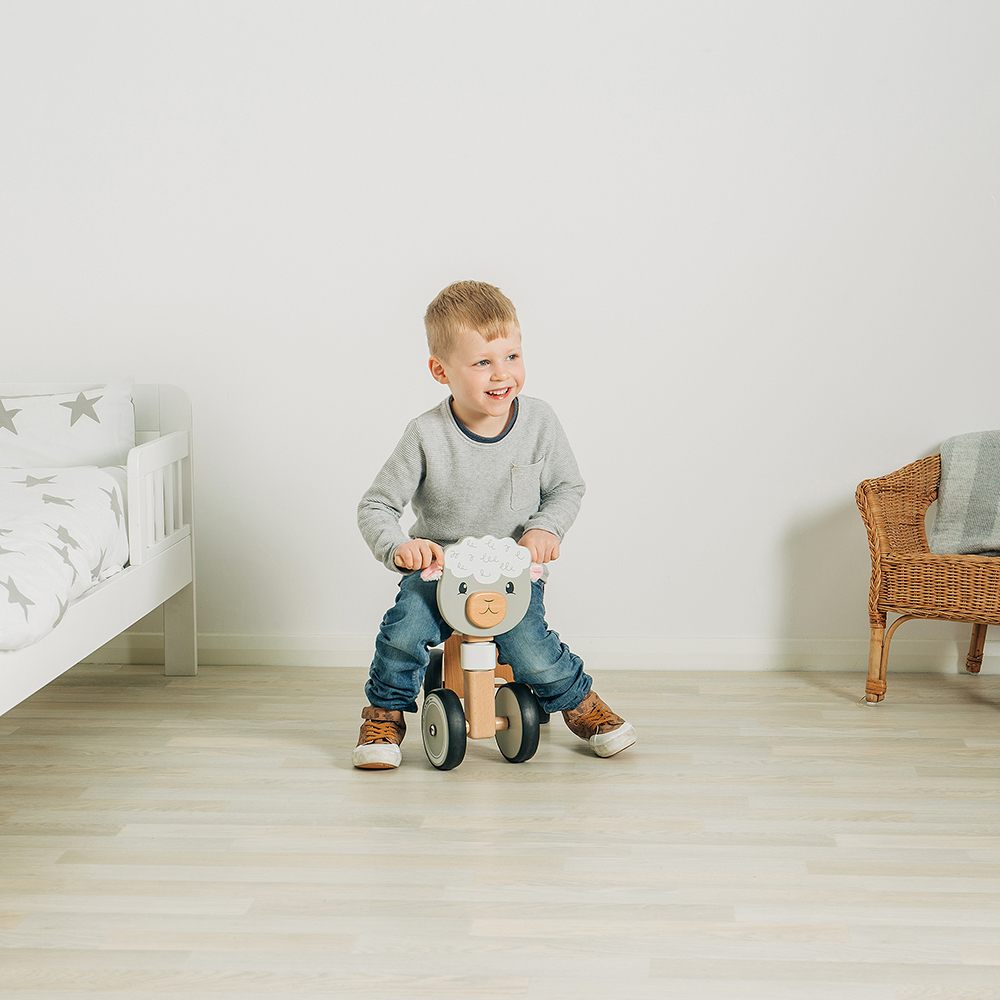 A young boy on a sheep ride-on toy 