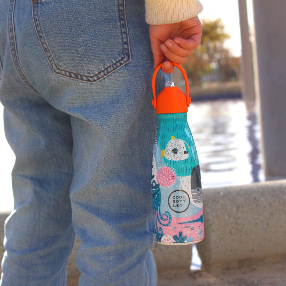 The back of a child in jeans holding a water bottle