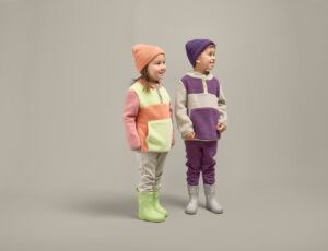 Two children in hats, Borg fleeces, trousers and wellies from Grass & Air's Fjørds Collection