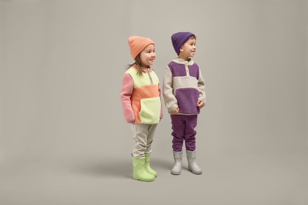 Two children in hats, Borg fleeces, trousers and wellies from Grass & Air's Fjørds Collection