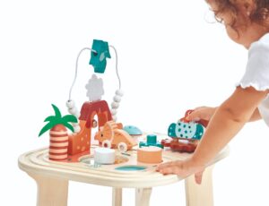 A child playing with the wooden Dino Activity Table by Jura Toys