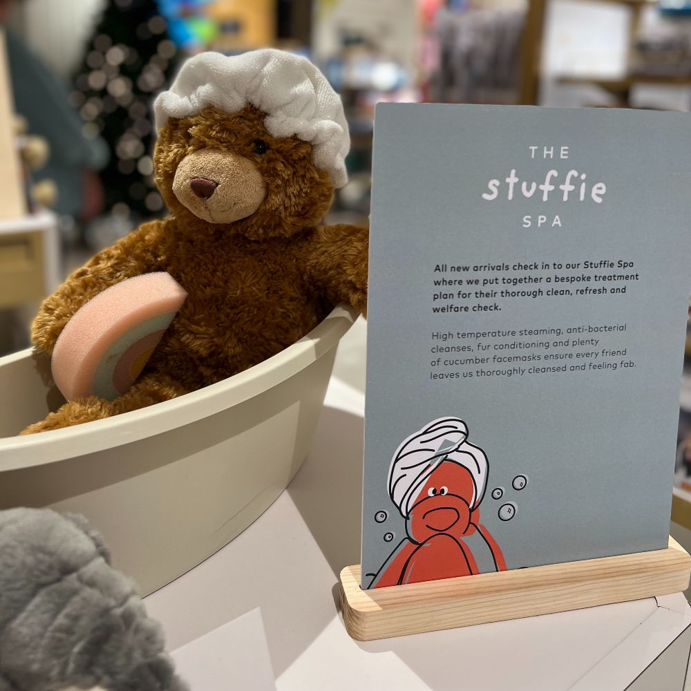 A teddy bear in a bath displayed in a store 