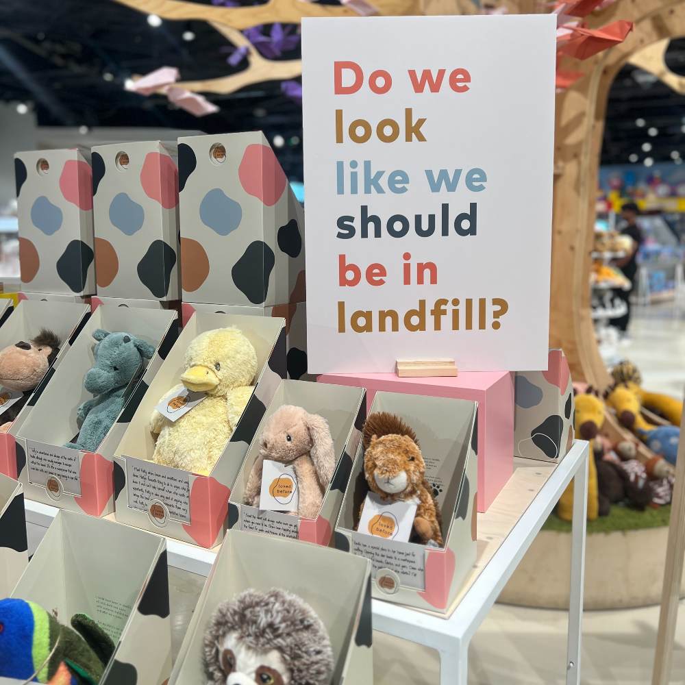 Children's soft toys by Loved Before in boxes displayed in a store 