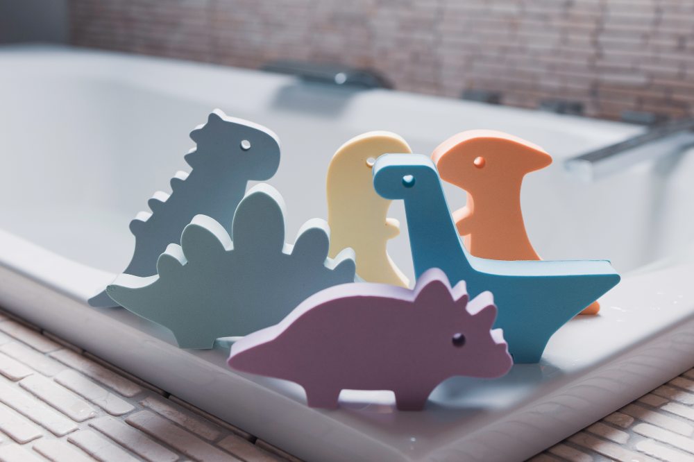 Children's dinosaur bath toys on the edge of a bath