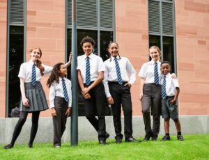 A group of children in school uniform stood outside a building