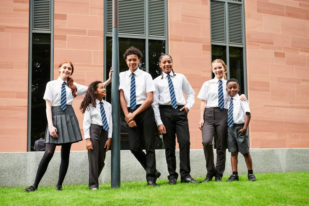 A group of children in school uniform stood outside a building