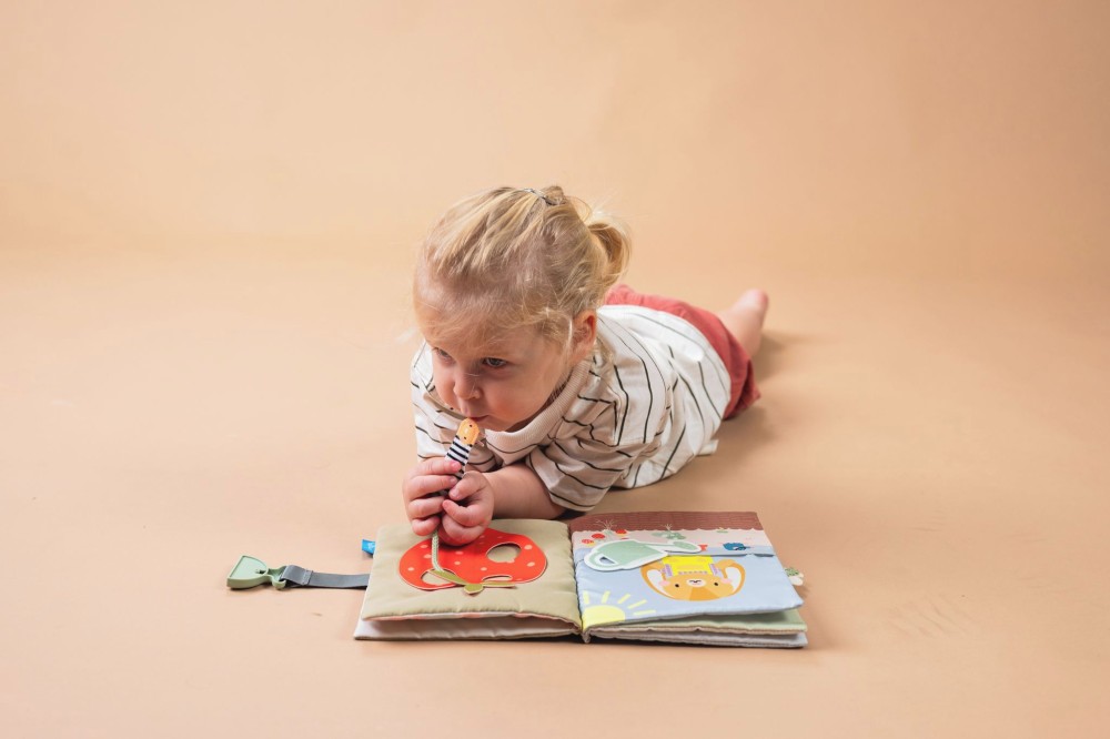 A child lying on the floor reading a book 