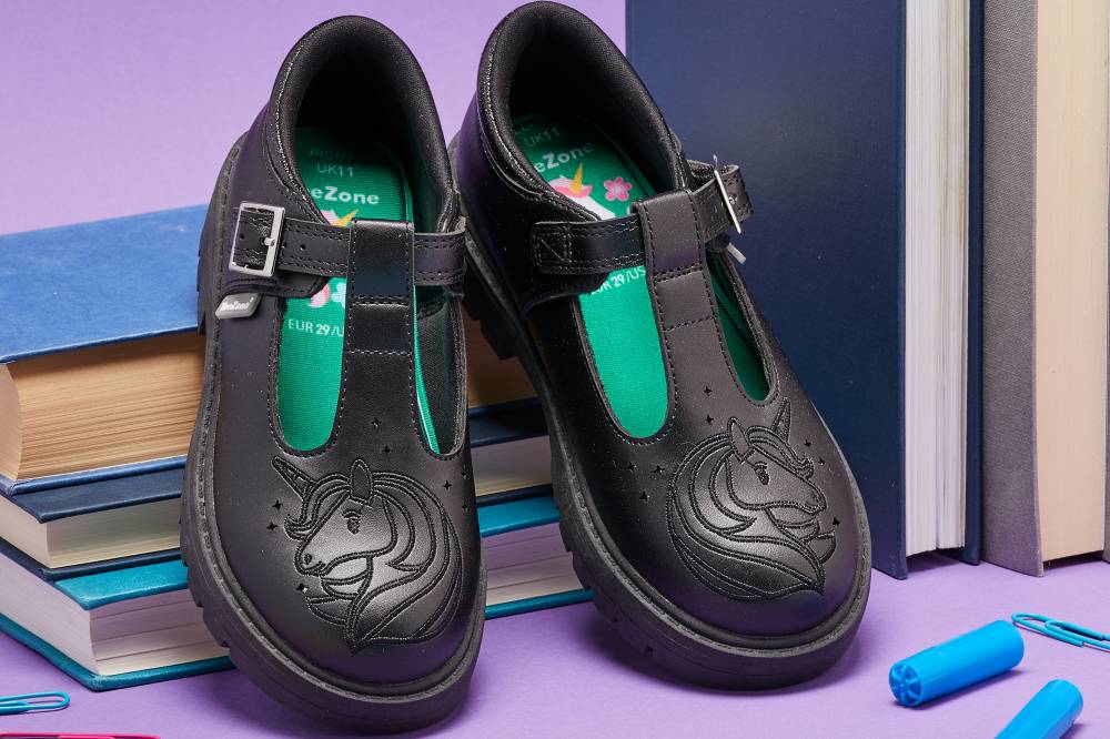 A pair of ToeZone black school shoes with unicorns embossed on the front