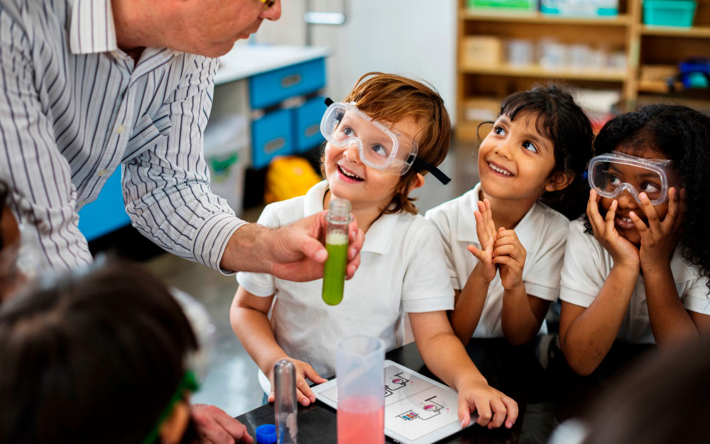 A school teacher and four children conducting a science experiment