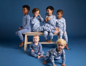 A young group of boys in a blue room wearing the new limited edition collection by PO.P in support of the Swedish Prostate Cancer Association