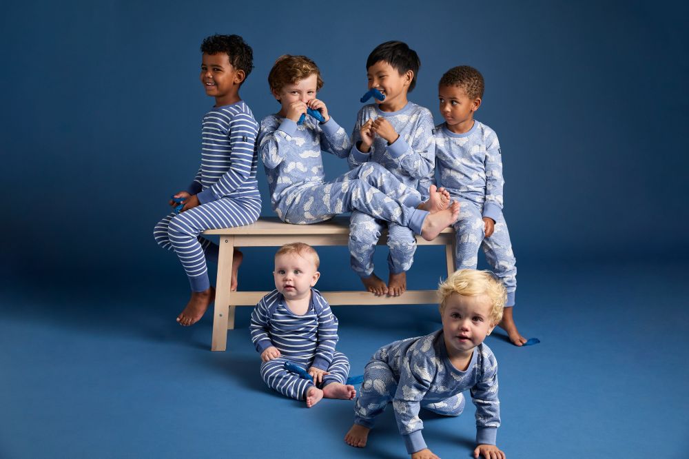 A young group of boys in a blue room wearing the new limited edition collection by PO.P in support of the Swedish Prostate Cancer Association