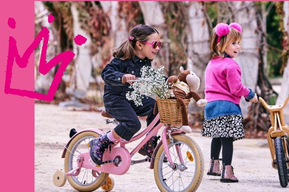 Two girls playing outside on bicycles 