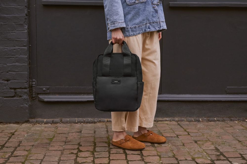 A person stood holding a black changing bag by Finnson