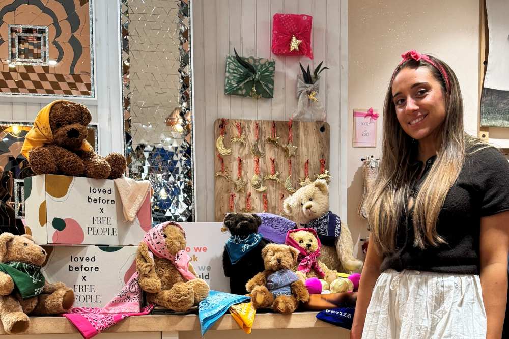 A woman stood beside a display of soft toys from the Loved Before x Free People collaboration