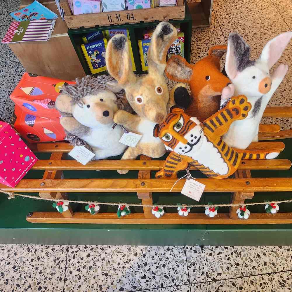 Children's teddies displayed on a Christmas sleigh in a shop 