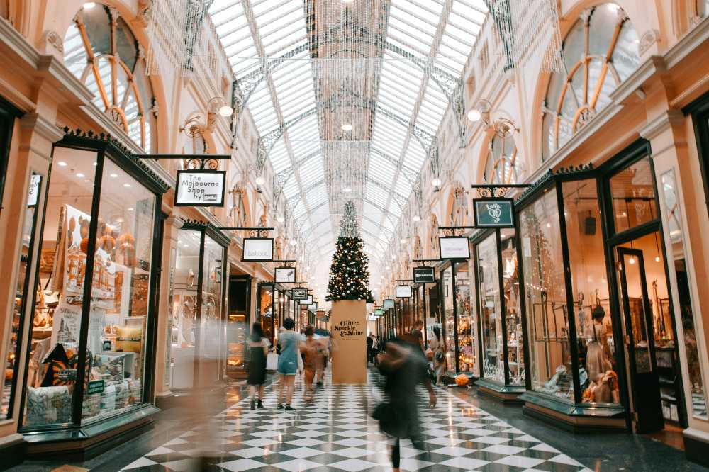 People walking through a shopping mall decorated for Christmas