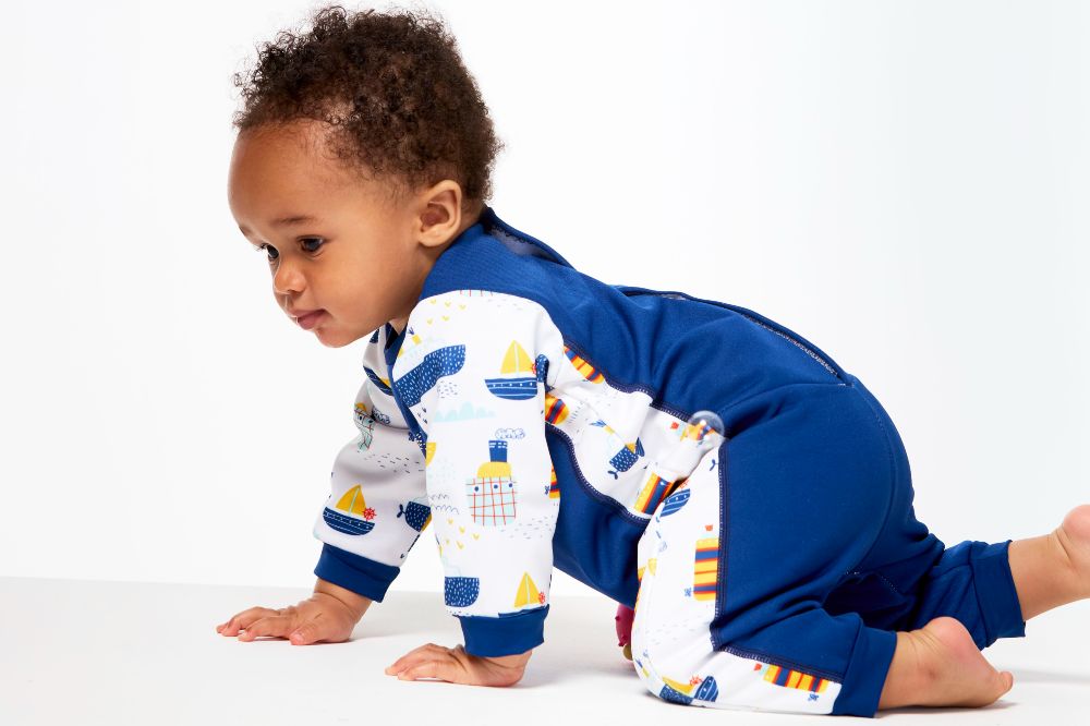 A young child crawling wearing a swimsuit by Splash About