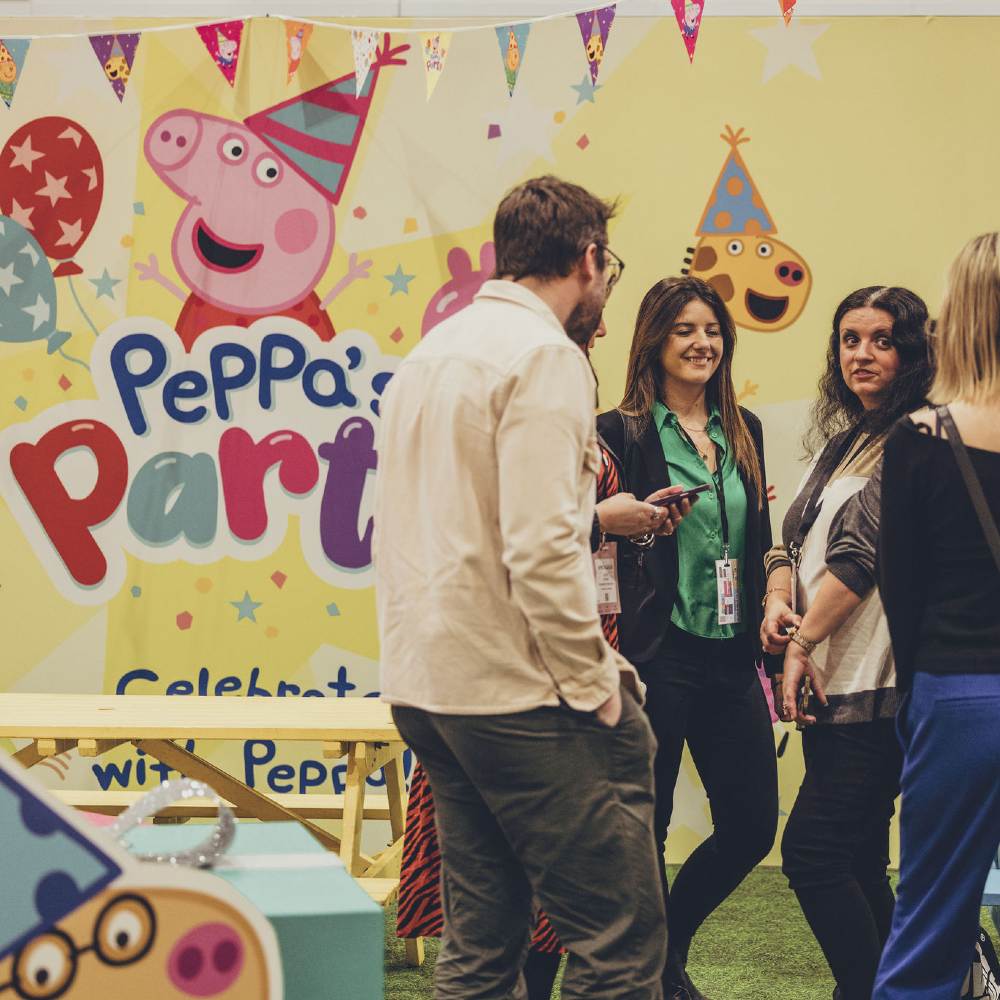 People stood in a room decorated with Peppa Pig marketing 