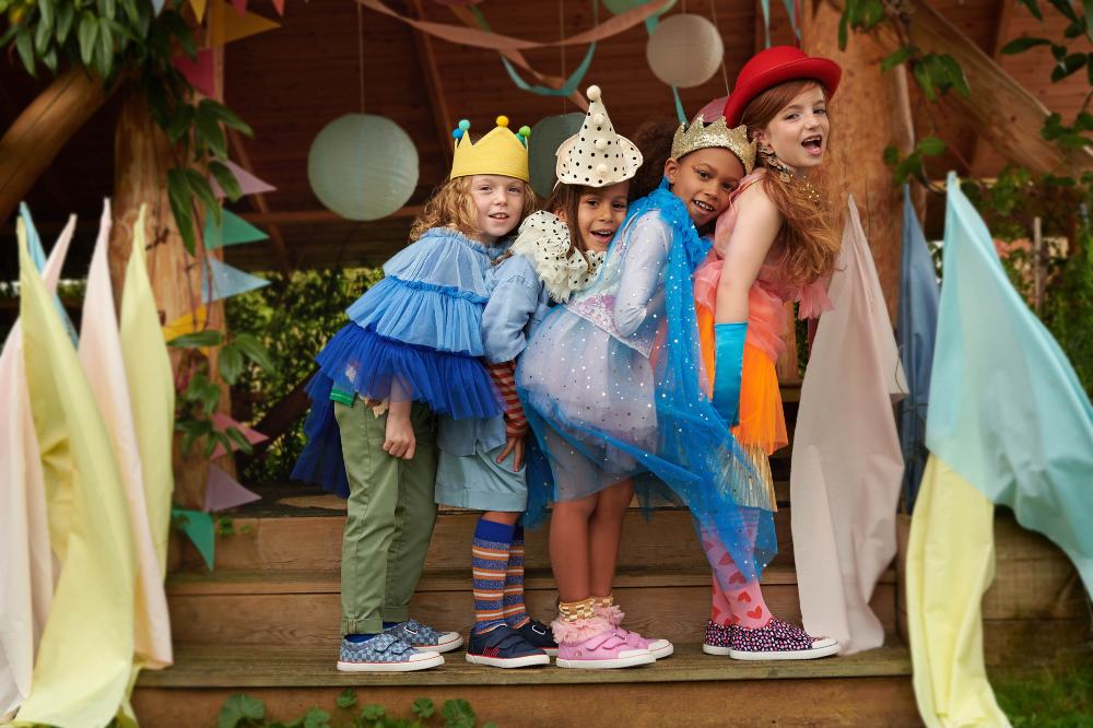 A group of children stood on wooden steps wearing partywear