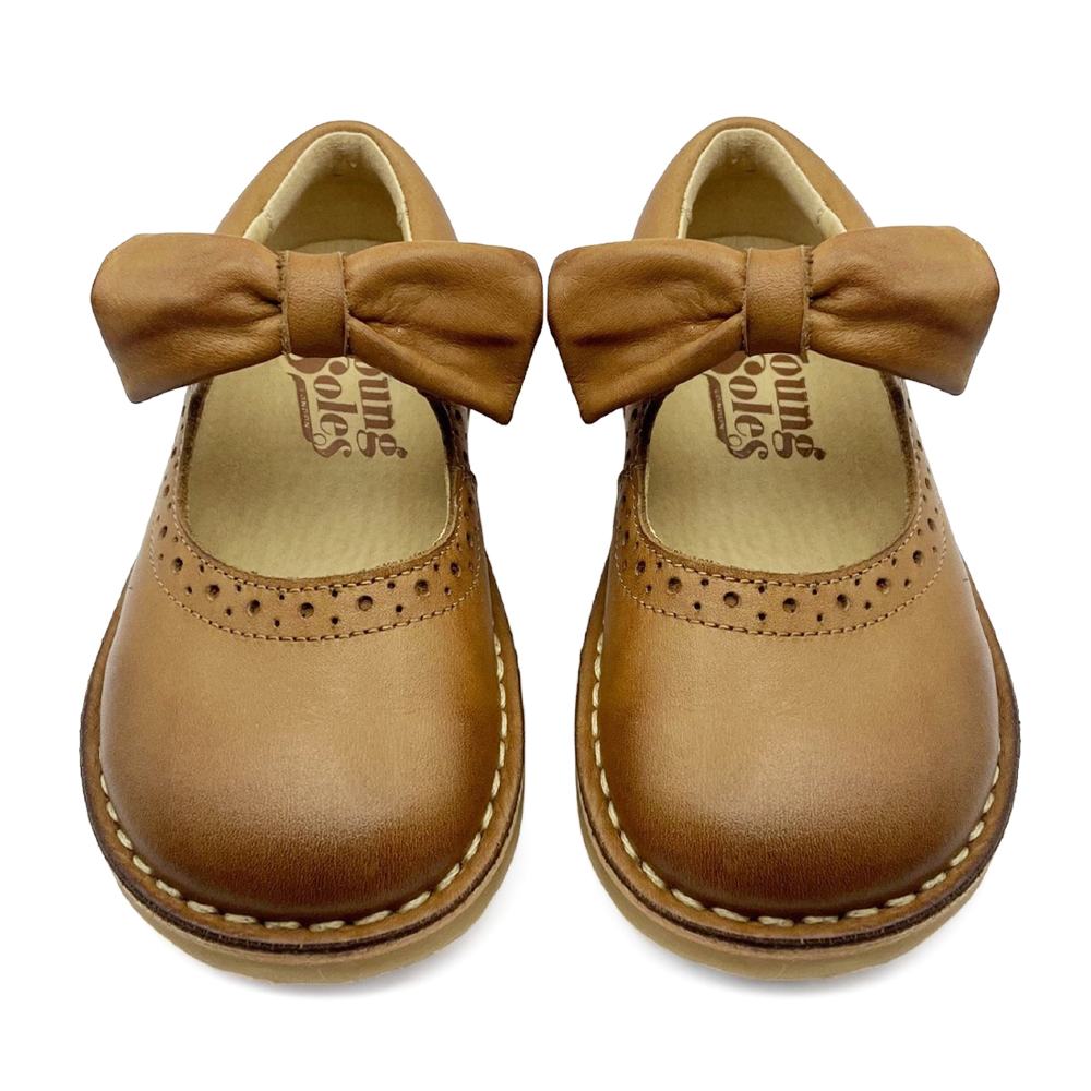 A pair of tan coloured children's shoes with bows 