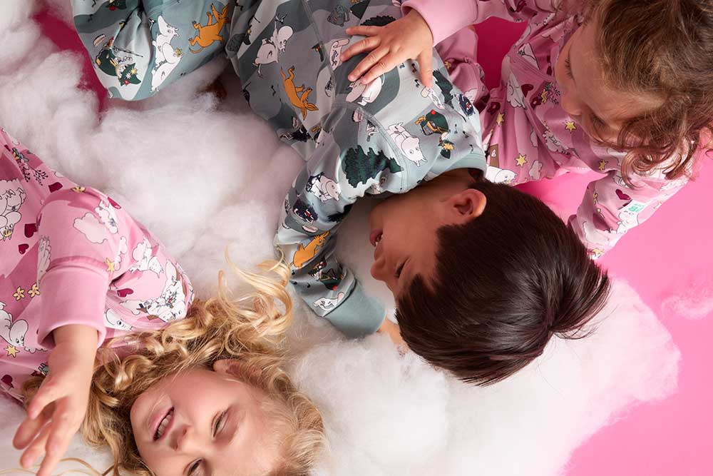 Two girls and a boy playing together on a the floor wearing outfits from PO.P's new Moomin collection