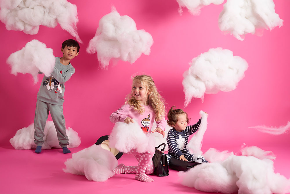 A boy and two young girls playing with cotton wool