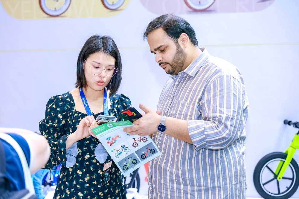 Two people looking at a catalogue at Baby & Stroller China