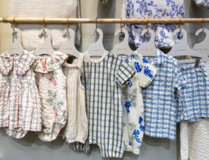 baby clothes displayed on a rail at Kind + Jugend